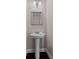 Bathroom featuring a pedestal sink, decorative mirror, and wood-look flooring at 244 Sturry Dr, Mcdonough, GA 30252