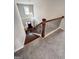 View of the home foyer from the top of carpeted stairs with wood railing at 244 Sturry Dr, Mcdonough, GA 30252