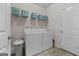 Bright laundry room equipped with a washer, dryer, shelving, and neutral-colored flooring at 244 Sturry Dr, Mcdonough, GA 30252