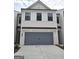 Stylish two-story home features a brick and siding exterior, a gray garage door and a paved driveway at 1946 Westwind Street # 132, Lawrenceville, GA 30043