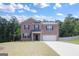 Brick two-story house with attached garage, driveway and landscaping at 4075 Spencer Trail, Stonecrest, GA 30038