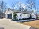 White brick home with a two-car garage and mature trees at 1200 Mount Carmel Rd, Mcdonough, GA 30253