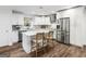 Updated kitchen features white cabinets, quartz countertops, stainless steel appliances, and an island with seating at 1200 Mount Carmel Rd, Mcdonough, GA 30253