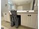 Bathroom vanity with white cabinets, light countertop, decorative chair and large mirror at 7963 Smith Rd, Villa Rica, GA 30180