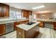 Bright kitchen with island cooktop, granite counters, stainless appliances, wood cabinetry and a window view at 7963 Smith Rd, Villa Rica, GA 30180