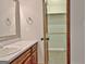 Bathroom with wood vanity, and large door to a walk-in closet with shelves and storage at 215 Kingswood Dr, Fayetteville, GA 30215