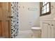 Bathroom featuring a toilet, geometric shower curtain, and window with natural light at 215 Kingswood Dr, Fayetteville, GA 30215