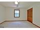 Carpeted bedroom with natural light, ceiling fan and wood closet doors at 215 Kingswood Dr, Fayetteville, GA 30215