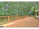 Expansive wooden deck surrounded by lush trees, offering a serene outdoor space at 215 Kingswood Dr, Fayetteville, GA 30215