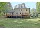 Home exterior featuring deck, brick foundation and wooded perimeter at 215 Kingswood Dr, Fayetteville, GA 30215