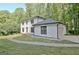 View of house from driveway, highlighting garage and landscaping at 215 Kingswood Dr, Fayetteville, GA 30215