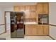 Kitchen featuring wooden cabinets, black appliances, and tile flooring at 215 Kingswood Dr, Fayetteville, GA 30215