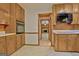 Kitchen with wooden cabinets and tile flooring leading to a room with fireplace at 215 Kingswood Dr, Fayetteville, GA 30215