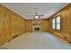 Living room with wood paneling, brick fireplace, ceiling fan, and light hardwood floors at 215 Kingswood Dr, Fayetteville, GA 30215