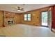 Living room with wood paneling, brick fireplace, light hardwood floors, and outdoor access at 215 Kingswood Dr, Fayetteville, GA 30215