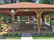 Community pool pavilion offers a shady place to relax with picnic tables, a clock, and pretty landscaping at 215 Kingswood Dr, Fayetteville, GA 30215