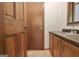 Powder room featuring wooden vanity with steel sink, mirror, and lighting at 215 Kingswood Dr, Fayetteville, GA 30215