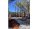 Land featuring a gravel driveway, surrounded by a lush forest, and a sign reading 