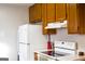 Close up of kitchen, featuring white appliances and wood-look cabinets and countertops at 106 Gwenellen Dr, Locust Grove, GA 30248