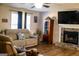 Comfortable living room showcasing stone fireplace, curio cabinet, wood-look flooring and sofa at 106 Gwenellen Dr, Locust Grove, GA 30248