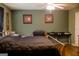 Bedroom with green walls, hardwood floors, and black storage bench at 106 Gwenellen Dr, Locust Grove, GA 30248