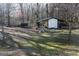 View of an outbuilding in a wooded lot with lots of space for activities at 106 Gwenellen Dr, Locust Grove, GA 30248
