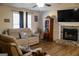 Cozy living room featuring a stone fireplace, plush sofa, and a ceiling fan for comfortable living at 106 Gwenellen Dr, Locust Grove, GA 30248