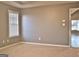 Well-lit bedroom with neutral walls and carpet, featuring a window with blinds and access to another room at 901 Arbor Way, Mcdonough, GA 30253