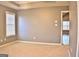 Well-lit bedroom with neutral walls and carpet, featuring a window with blinds and access to another room at 901 Arbor Way, Mcdonough, GA 30253