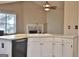 Kitchen features island with double sink, white cabinets and fireplace at 901 Arbor Way, Mcdonough, GA 30253