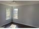 A light and airy bedroom offers two windows and wood-look flooring at 9418 Sleepy Hollow Ln, Jonesboro, GA 30238