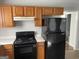 Kitchen with wood cabinets, black appliances, and white countertops at 9418 Sleepy Hollow Ln, Jonesboro, GA 30238