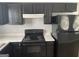 Close-up of the kitchen with black appliances and white countertops at 9418 Sleepy Hollow Ln, Jonesboro, GA 30238