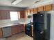 Kitchen with wood cabinets, black appliances, and white countertops at 9418 Sleepy Hollow Ln, Jonesboro, GA 30238