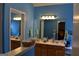 Bright blue bathroom featuring double sinks, large mirrors, and ample counter space at 213 Meridian Dr, Stockbridge, GA 30281