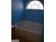 Bathroom features a luxurious tub with a sleek faucet, along with a stylish arched window for natural light at 213 Meridian Dr, Stockbridge, GA 30281