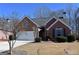 Charming brick home with a manicured lawn, attached garage, and mature trees on a sunny day at 213 Meridian Dr, Stockbridge, GA 30281