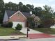 Beautiful red brick home featuring a well-maintained lawn, mature trees, and a cozy residential setting at 213 Meridian Dr, Stockbridge, GA 30281