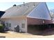 Home exterior with siding, a brick accent, tidy bushes, a dark grill, and some patio furniture at 213 Meridian Dr, Stockbridge, GA 30281