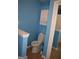 Compact toilet area with a white toilet, cabinet and neutral flooring, blending practicality with simplicity at 213 Meridian Dr, Stockbridge, GA 30281