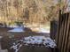 Partially snow-covered backyard with wooden fence and chain link at 2590 Wellington Walk Pl, Lithonia, GA 30058