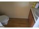 Half bathroom with a wood-look floor, toilet, and small vanity with sink at 2590 Wellington Walk Pl, Lithonia, GA 30058
