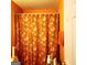 Simple bathroom with shower and orange floral curtain at 6709 Biscayne Blvd, Rex, GA 30273