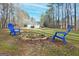 Fire pit with blue chairs and wooded backdrop at 140 Alford Dr, Fayetteville, GA 30215