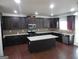 Modern kitchen with dark cabinets, granite counters, and island at 1340 Napa Valley Dr, Lawrenceville, GA 30045