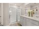 Bright bathroom featuring double sinks, white cabinetry, a glass-enclosed shower, and neutral décor at 205 Friendship Oak Way, Hampton, GA 30228