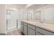 Clean bathroom featuring double vanity, gray cabinets, and a walk-in shower with glass door at 205 Friendship Oak Way, Hampton, GA 30228
