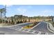Wide view of the Oakchase at Hampton entrance with lush landscaping and signage at 205 Friendship Oak Way, Hampton, GA 30228