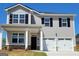 Charming two-story home with gray siding, black shutters, and a two-car garage offers classic curb appeal at 205 Friendship Oak Way, Hampton, GA 30228