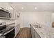 Well-equipped kitchen with stainless steel appliances, granite countertops, and wood flooring at 205 Friendship Oak Way, Hampton, GA 30228